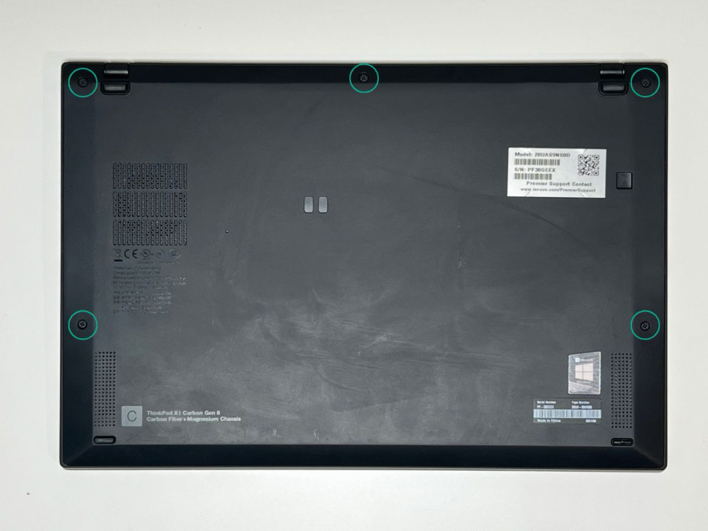 Zdjęcie pokazujące dolną obudowę laptopa Lenovo carbon x1 G8 z zaznaczonymi śrubami do odkręcenia. 